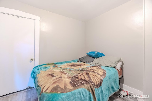 bedroom with baseboards and wood finished floors