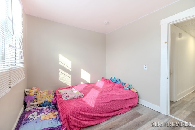 bedroom with light wood-type flooring and baseboards