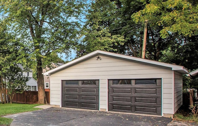 detached garage featuring fence