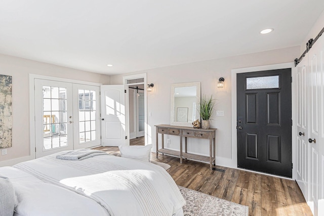 foyer featuring a barn door, baseboards, wood finished floors, french doors, and recessed lighting