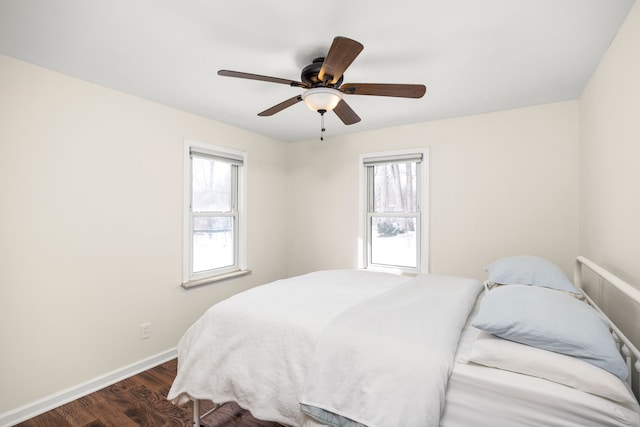 bedroom with a ceiling fan, dark wood finished floors, and baseboards