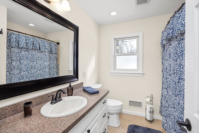 bathroom with toilet, vanity, visible vents, and baseboards