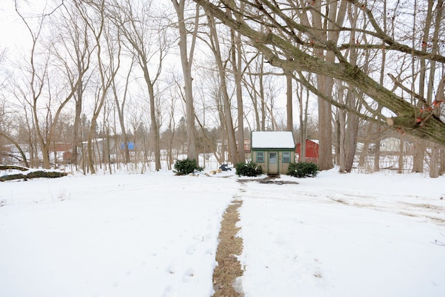 yard layered in snow with an outbuilding