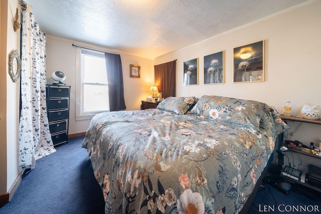 bedroom featuring baseboards, dark carpet, and a textured ceiling