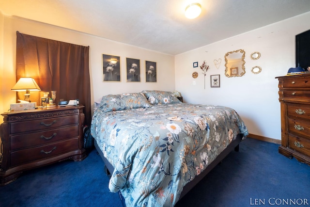 bedroom with baseboards and dark carpet