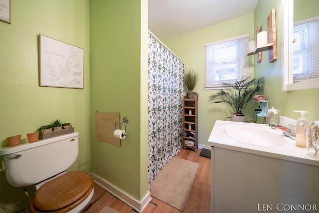 bathroom featuring baseboards, vanity, toilet, and wood finished floors