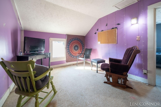 sitting room with visible vents, light colored carpet, vaulted ceiling, a textured ceiling, and baseboards