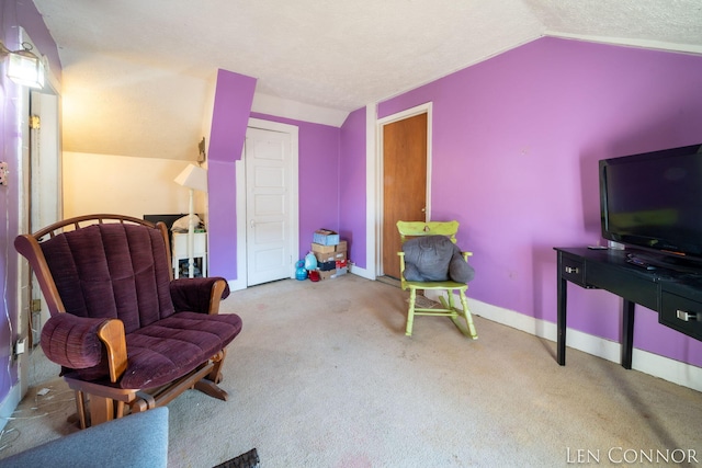 sitting room with vaulted ceiling, a textured ceiling, light carpet, and baseboards