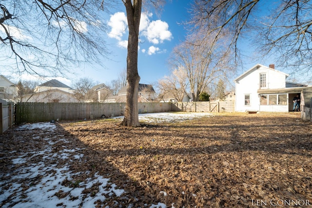 view of yard featuring a sunroom and a fenced backyard