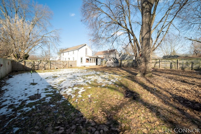 yard covered in snow with a fenced backyard