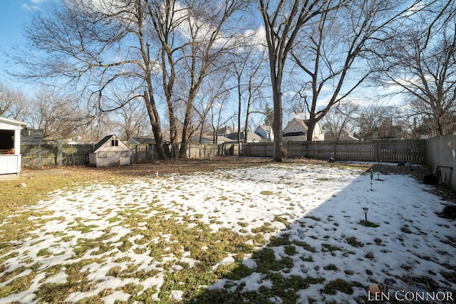 yard covered in snow with a fenced backyard and a residential view