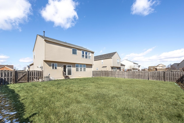 back of house featuring entry steps, a fenced backyard, a residential view, and a lawn