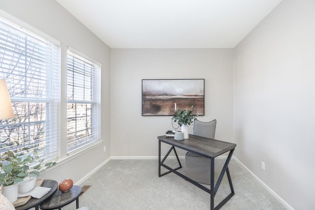 office area featuring light carpet and baseboards