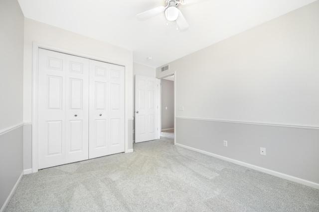 unfurnished bedroom featuring baseboards, a closet, visible vents, and light colored carpet