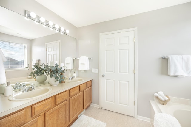 full bath featuring double vanity, a sink, a bathing tub, and baseboards