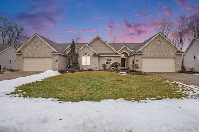 view of front of property with a garage, driveway, brick siding, and a lawn