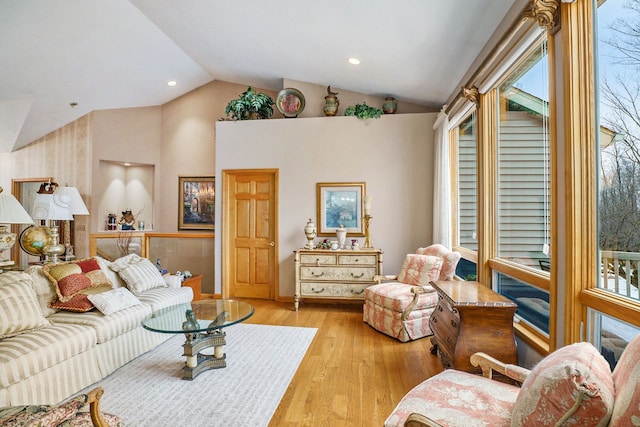 living room featuring light wood-style floors, a wealth of natural light, vaulted ceiling, and recessed lighting