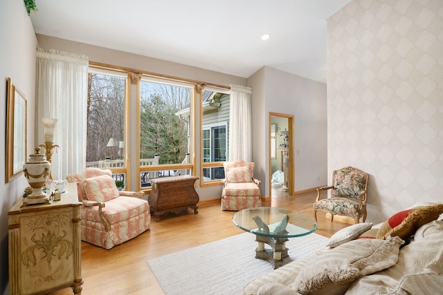 living room featuring recessed lighting, an accent wall, baseboards, light wood-type flooring, and wallpapered walls