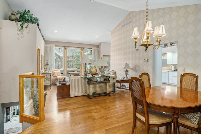 dining area with wallpapered walls, visible vents, a chandelier, and light wood-style floors