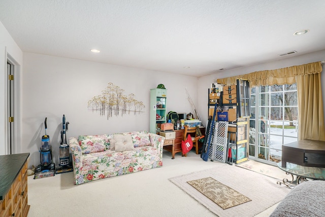 carpeted living room featuring a textured ceiling, visible vents, and recessed lighting