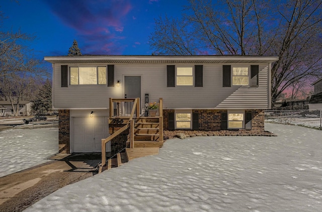 split foyer home featuring a garage and brick siding