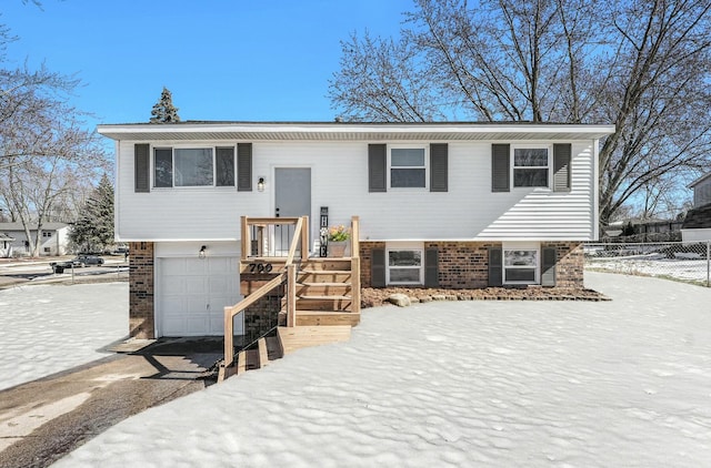 raised ranch with an attached garage and brick siding