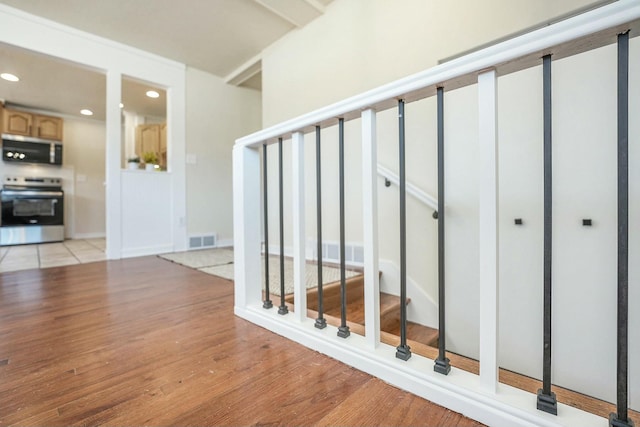 stairway featuring visible vents, wood finished floors, and recessed lighting