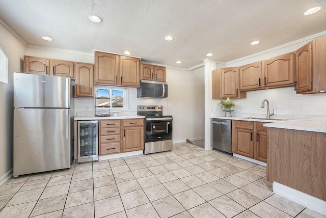 kitchen featuring beverage cooler, tasteful backsplash, stainless steel appliances, light countertops, and a sink