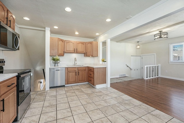 kitchen with visible vents, appliances with stainless steel finishes, light countertops, and a sink