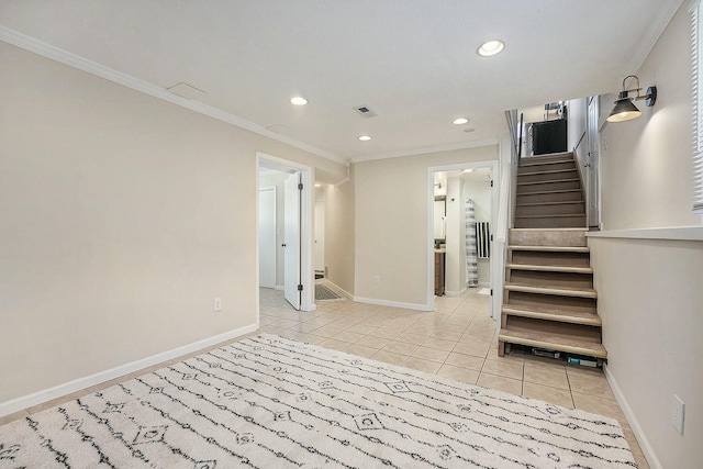 spare room with ornamental molding, light tile patterned flooring, and baseboards