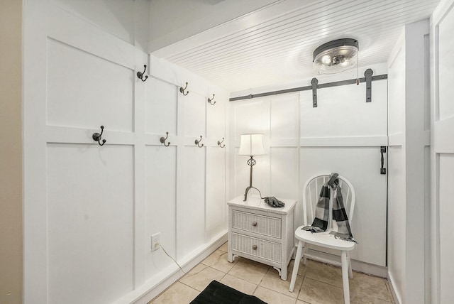 mudroom with light tile patterned floors and a barn door