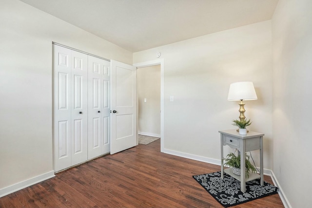 interior space with dark wood-style floors, a closet, and baseboards