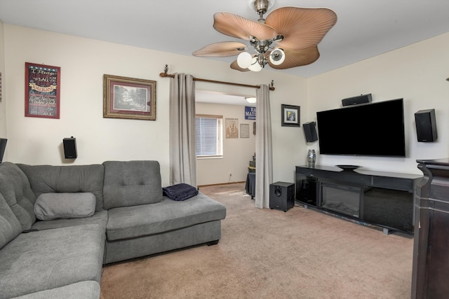 living room with a ceiling fan and carpet