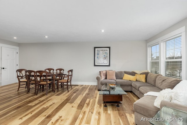 living area with light wood-type flooring, baseboards, and recessed lighting