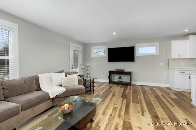 living room with plenty of natural light, light wood-style flooring, and baseboards