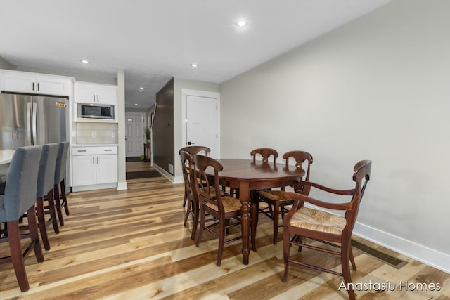 dining space featuring light wood-style floors, baseboards, and recessed lighting