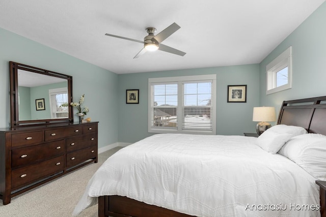 bedroom featuring light carpet, a ceiling fan, and baseboards