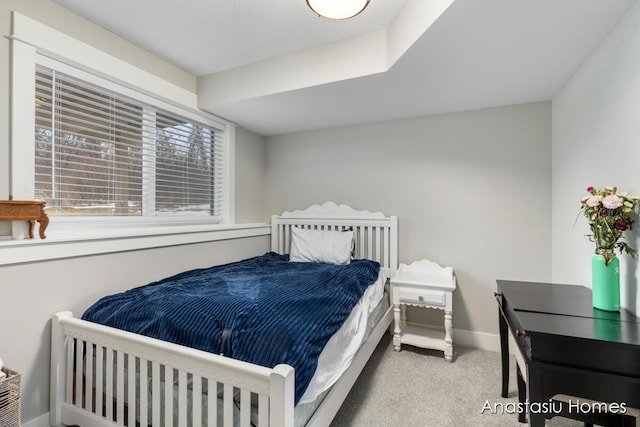 bedroom featuring light carpet and baseboards