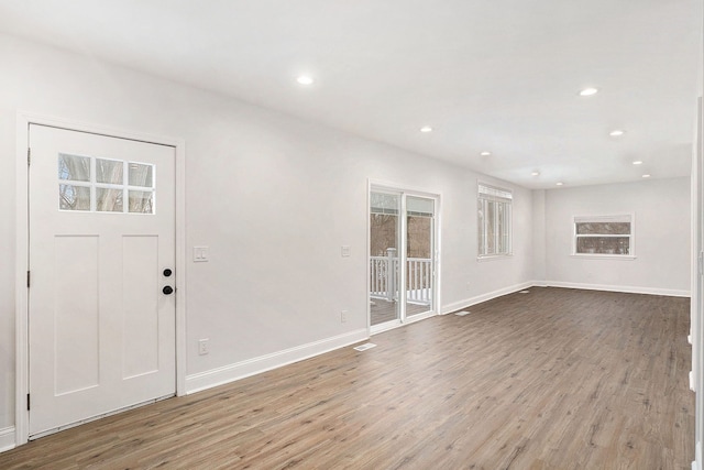 foyer entrance with baseboards, wood finished floors, and recessed lighting