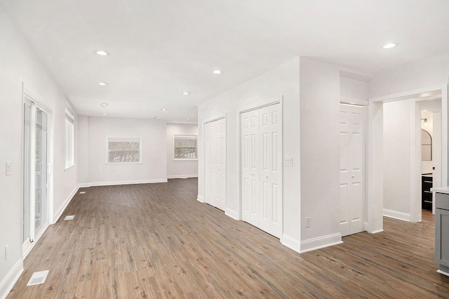 empty room featuring baseboards, wood finished floors, visible vents, and recessed lighting