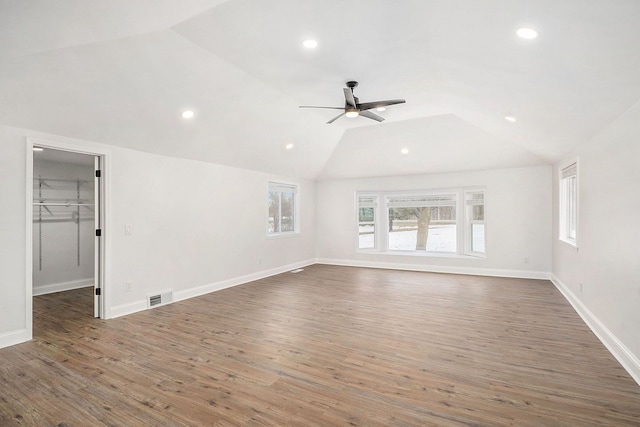 unfurnished living room with lofted ceiling, visible vents, baseboards, and wood finished floors