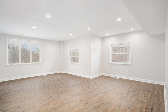 unfurnished room with recessed lighting, baseboards, and wood finished floors