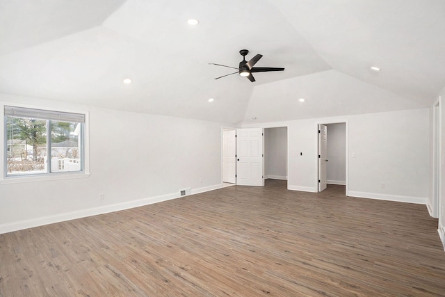 interior space with visible vents, ceiling fan, vaulted ceiling, wood finished floors, and baseboards