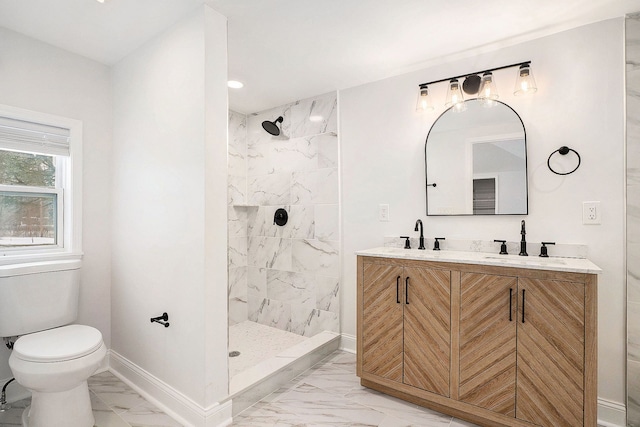 bathroom with marble finish floor, baseboards, a tile shower, and a sink