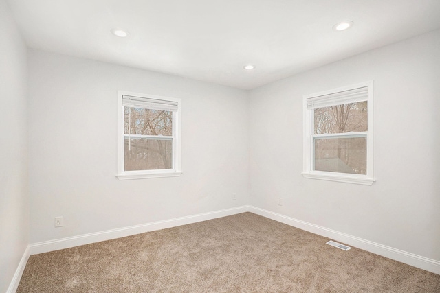 empty room featuring recessed lighting, carpet flooring, visible vents, and baseboards