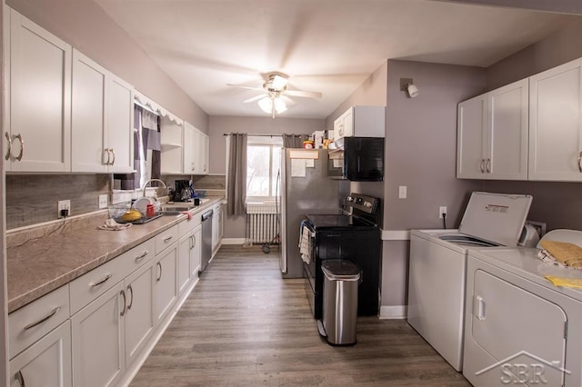 kitchen with a ceiling fan, white cabinetry, a sink, independent washer and dryer, and black appliances