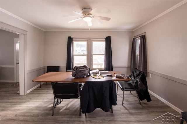 dining room with ornamental molding, wood finished floors, a ceiling fan, and baseboards