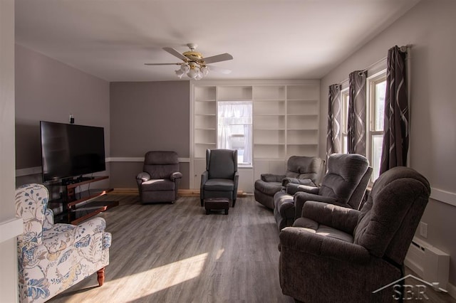 living room with ceiling fan, baseboards, baseboard heating, and wood finished floors