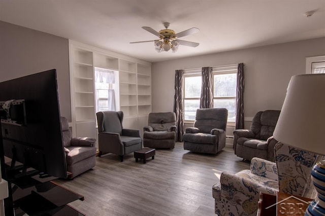 living area with a ceiling fan and wood finished floors