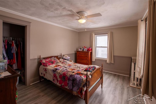 bedroom featuring dark wood-style floors, a spacious closet, and ornamental molding